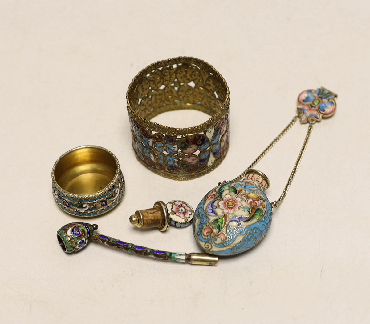 A late 19th/early 20th century Russian gilt 84 zolotnik and polychrome enamel pipe, 73mm, similar later scent bottle and salt and a brass? and enamelled napkin ring.